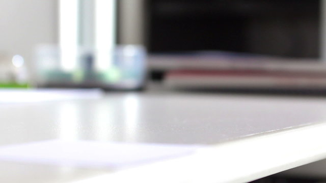 Woman hands taking a blue pen on a white desktop in a office