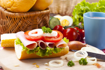 Breakfast sandwich with vegetables and a cup of hot cocoa.