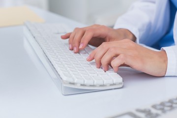 Doctors hands using computer keyboard