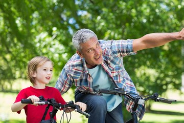 Obraz premium Happy father on a bike with his son