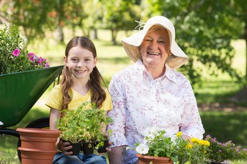 Happy grandmother with her granddaughter gardening