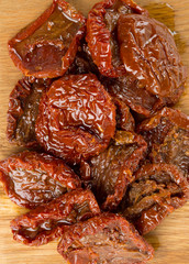 sun dried tomatoes with olive oil on wooden surface