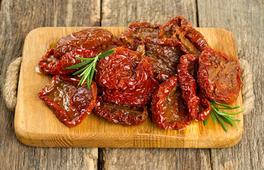 sun dried tomatoes with olive oil on wooden surface