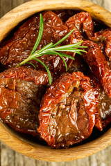 sun dried tomatoes with olive oil on wooden surface
