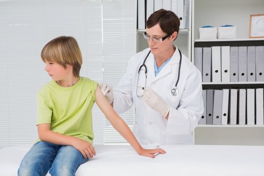 Doctor doing injection at little boy
