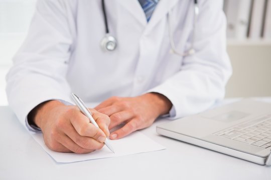 Doctor writing on a notepad