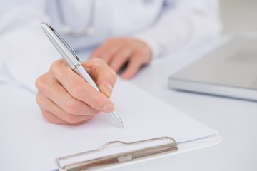 Doctor writing on a clipboard