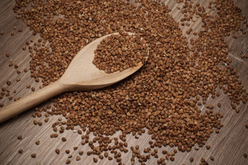 buckwheat groats on wooden spoon