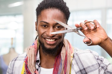 Happy male fashion designer holding scissors
