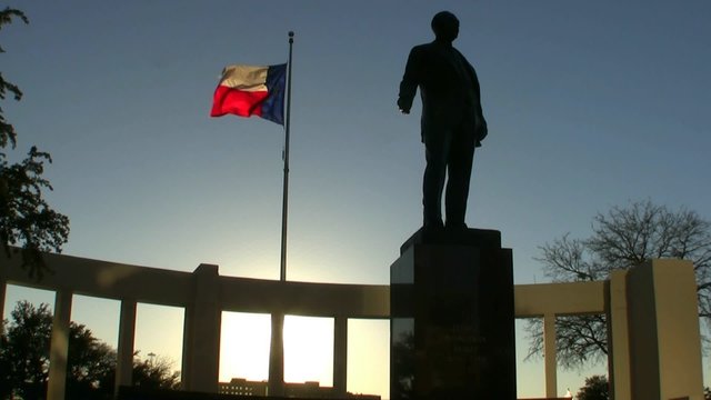 Texas Flag And Statue At Sunset