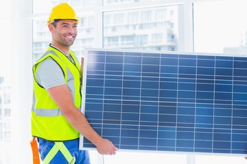 Fototapeta na wymiar Manual worker carrying solar panel at office