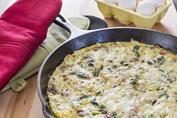 Frittata in a cast iron skillet with eggs, broccoli & spinach