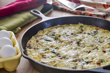Frittata in a cast iron skillet with eggs, broccoli & spinach