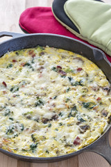 Frittata in a cast iron skillet with eggs, broccoli & spinach
