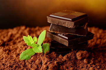 Heap of blocks of chocolate on cocoa powder