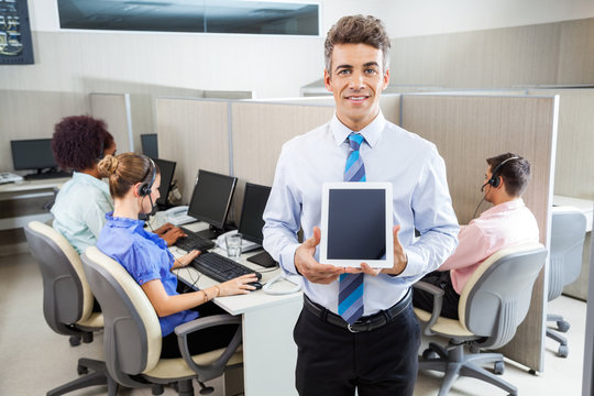 Smiling Manager Holding Tablet Computer At Call Center