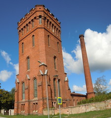 Fototapeta premium Old water tower and tall brick chimney (Liepaja, Latvia)