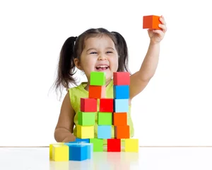 Fotobehang Lego child plays with building blocks and shows red cube  © Oksana Kuzmina