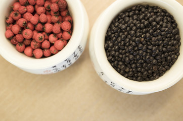 black lentils and red berries in a porcelain cup close up