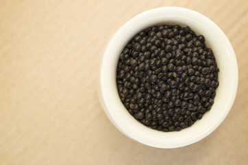 black lentils in a porcelain cup close up