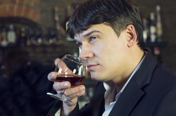 young man drinking brandy in a restaurant