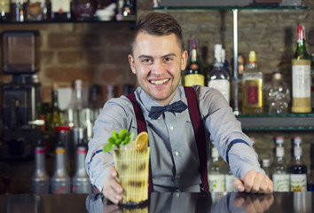 young man working as a bartender in a nightclub bar