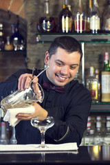 young man working as a bartender in a nightclub bar