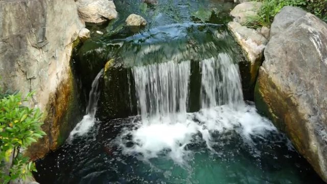 Waterfall runs into a Koi pond at Sensoji Temple Tokyo Japan