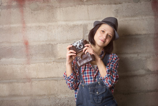 Indoor portrait of woman in a hipster style with vintage camera