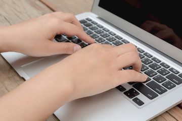 Closeup of business woman hand typing on laptop keyboard