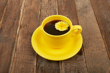 Cup of coffee with spices and flower on a wooden table backgroun