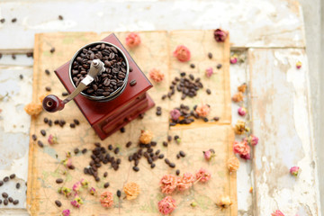 Coffee beans and dried roses scattered upon the old map