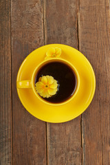 Cup of coffee with spices and flower on a wooden table backgroun