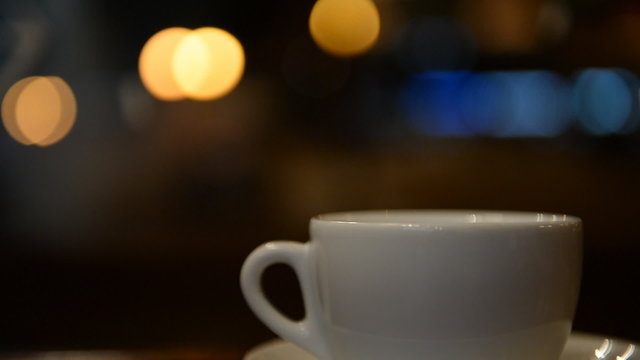 Teapot, cup closeup at night cafe, a restaurant on the street ba