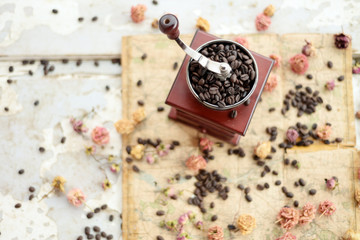 Coffee beans and dried roses scattered upon the old map