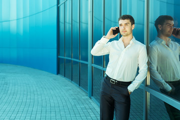 Young handsome succesfull bussiness man in suit speaking over th