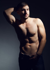 Fototapeta na wymiar Portrait of nude muscular fitness male model in jeans.