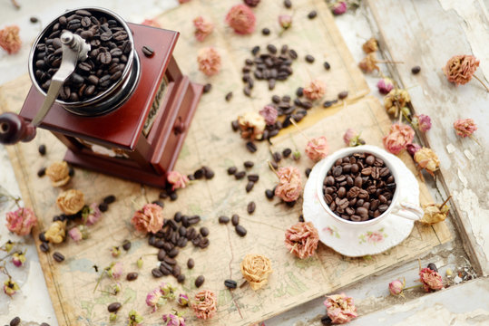 Coffee beans and dried roses scattered upon the old map © Nadiyka