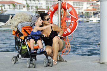Fototapeta na wymiar Happy mother and son in carriage enjoying holidays time
