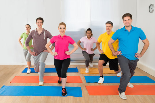 Group Of People Exercising On Mat