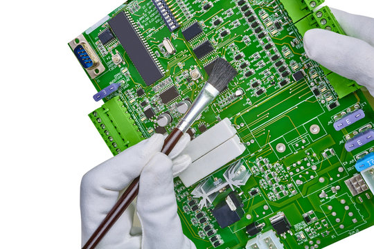 White gloved hands and brush cleaning computer circuit board cpu