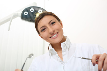 beautiful woman dentist ready to examine the patient