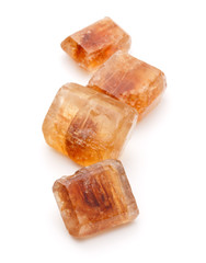 Brown caramelized lump cane sugar cube isolated on white backgro