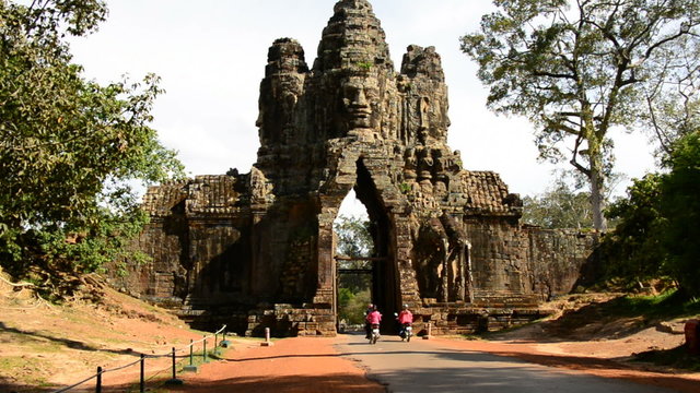 Zoom Out - Mopeds Drive through Archway on Bridge - Angkor Wat, Cambodia