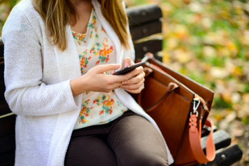 Woman using mobile smart phone in the park