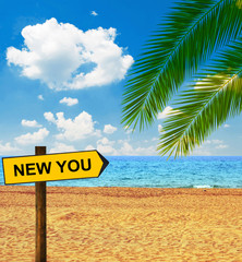 Tropical beach and direction board saying NEW YOU