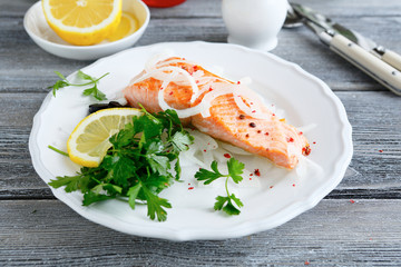 Red fish on a plate with lemon and parsley