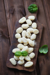 Raw gnocchi over rustic cutting board, high angle view