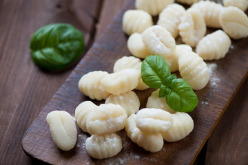 Rustic chopping board with raw gnocchi, studio shot, close-up