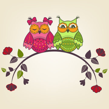Two beautiful owls on a branch with flowers